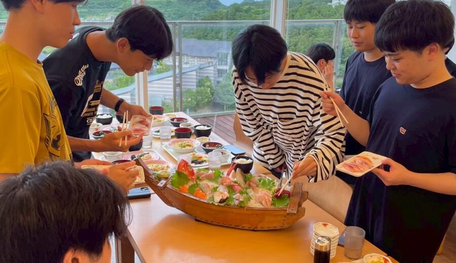 冬合宿で刺身の盛り合わせを囲む研究室メンバー